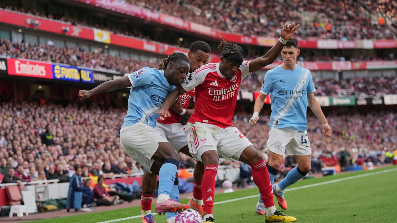 Manchester City's Jeremy Doku, left, and Arsenal's Noni Madueke fight for the ball during the Premier League soccer match between Arsenal and Manchester City in London, Sunday, Sept. 21, 2025. (AP Photo/Kin Cheung)