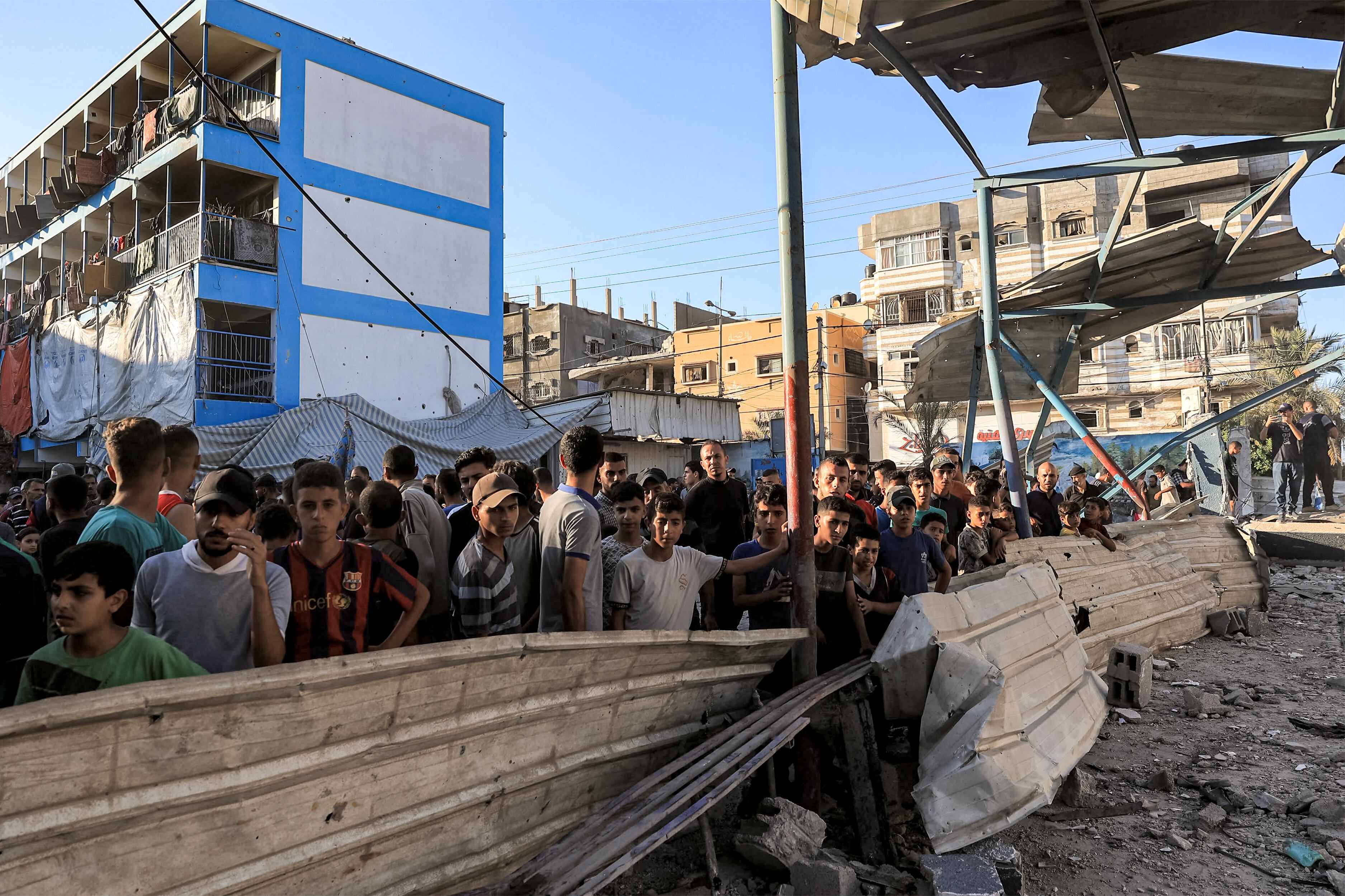 People gather to search the rubble of a collapsed building in the aftermath of Israeli bombardment at the Jaouni school run by the UN Relief and Works Agency for Palestine Refugees (UNRWA) in Nuseirat in the central Gaza Strip on July 6, 2024 amid the ongoing conflict in the Palestinian territory between Israel and Hamas. (Photo by Eyad BABA / AFP)
