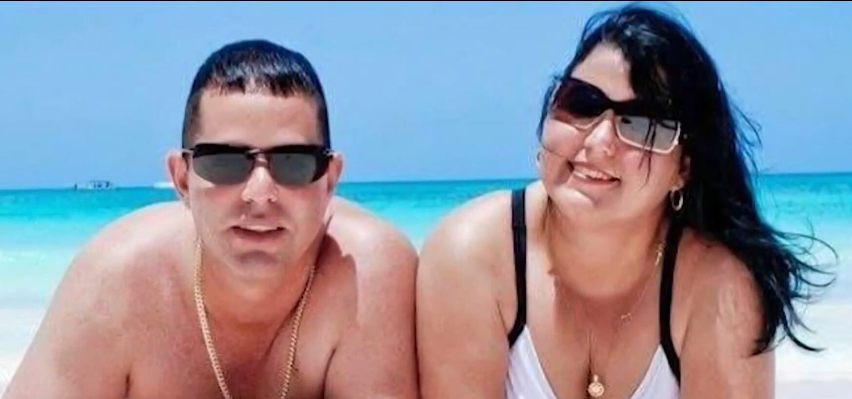 Yudaisy Salgueiro y su pareja posan en un espacio social, vestidos de manera elegante y sonrientes.