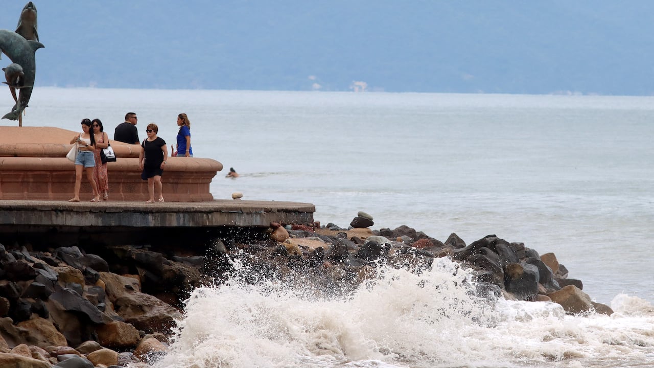 Tourists stroll along the coast of Puerto Vallarta, Jalisco State, Mexico, on October 10, 2023, hours before Hurricane Lidia is expected to reach Mexico's Pacific coast. Hurricane Lidia strengthened to a major Category 3 storm on Tuesday as it headed toward beach resorts on Mexico's Pacific coast, threatening to bring flooding and mudslides, forecasters said. (Photo by ULISES RUIZ / AFP)