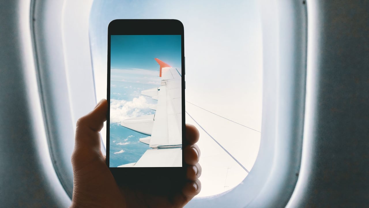 Imagen de referencia de persona tomando fotos desde el avión.