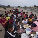 A group of nuns distribute food to migrants resting rest along the train tracks in Huehuetoca, Mexico, Friday, May 12, 2023, as they look to board a freight train heading north, the day after U.S. pandemic-related asylum restrictions called Title 42 were lifted. (AP Photo/Marco Ugarte)