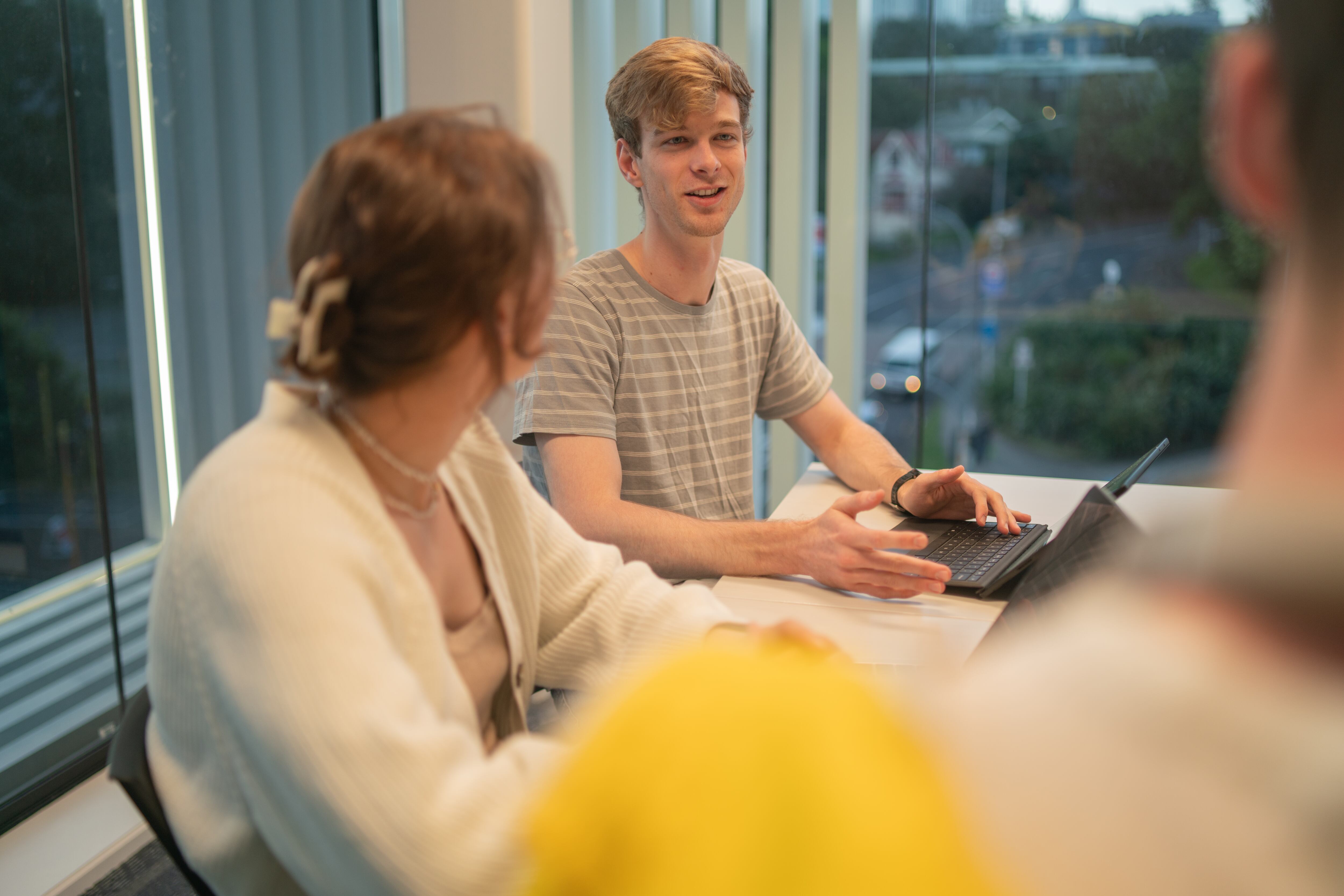 Un joven estudiante que estudia en la biblioteca con sus compañeros