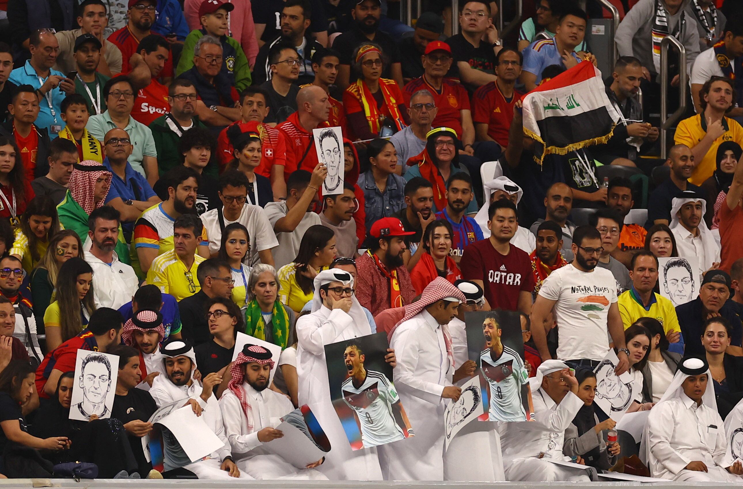 Soccer Football - FIFA World Cup Qatar 2022 - Group E - Spain v Germany - Al Bayt Stadium, Al Khor, Qatar - November 27, 2022 Fans hold up signs displaying former Germany player Mesut Ozil in the stands REUTERS/Kai Pfaffenbach