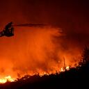 Un bombero dirige agua a alta presión desde una manguera hacia las llamas invasoras mientras los equipos luchan contra un gran incendio forestal en las estribaciones de la cordillera de Pentadaktylos en el norte separatista de Chipre étnicamente dividido el jueves, 23 de junio de 2022. Foto AP/Nedim Enginsoy