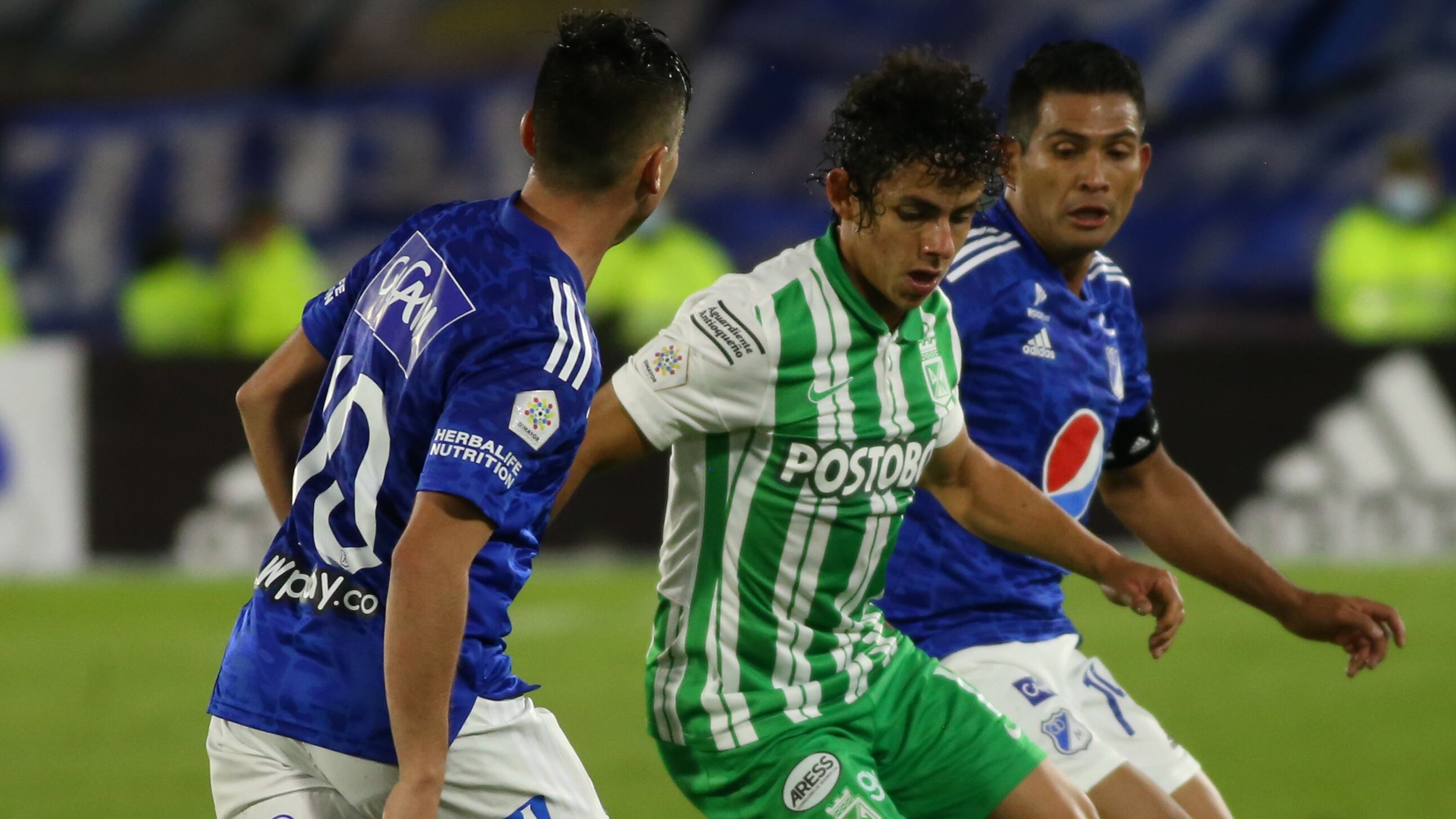 David Macalister Silva de Millonarios y Daniel Mantilla de Atlético Nacional disputan la pelota en el duelo de la Liga BetPlay.