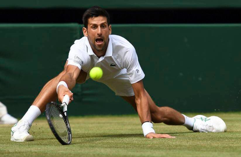 El serbio Novak Djokovic regresa una bola a Roberto Bautista Agut, de España, en las semifinales individuales masculinas del Campeonato de Tenis de Wimbledon en Londres, el viernes 12 de julio de 2019. (Andy Rain / Pool Photo via AP)