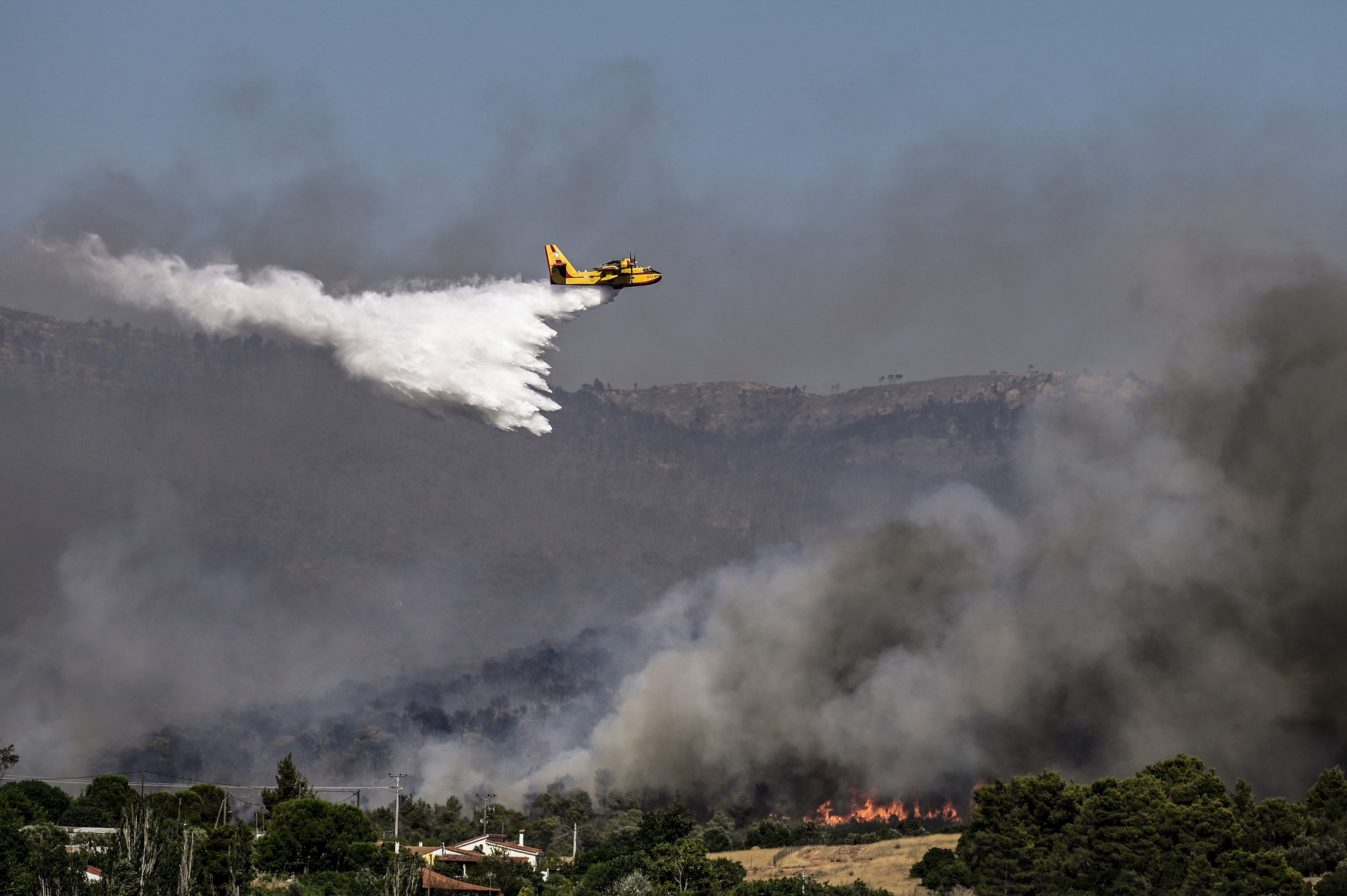 Un avión de extinción de incendios de Canadair rocía agua durante un incendio en Dervenochoria, al noroeste de Atenas.