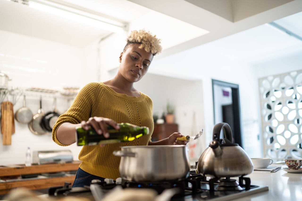 Mujer cocinando con aceite de oliva
