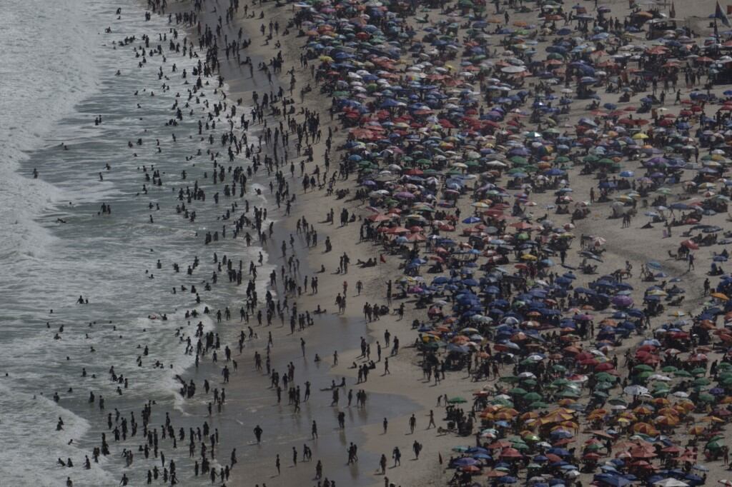 La gente disfruta del día en la playa de Copacabana en Río de Janeiro, Brasil, el 16 de febrero de 2025. (Foto de Pablo PORCIUNCULA / AFP)