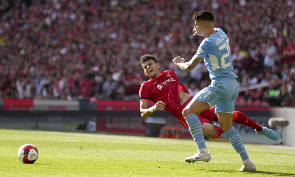 Manchester City's Joao Cancelo fights for the ball with Liverpool's Luis Diaz, left, during the English FA Cup semifinal soccer match between Manchester City and Liverpool at Wembley stadium in London, Saturday, April 16, 2022. (AP/Kirsty Wigglesworth)