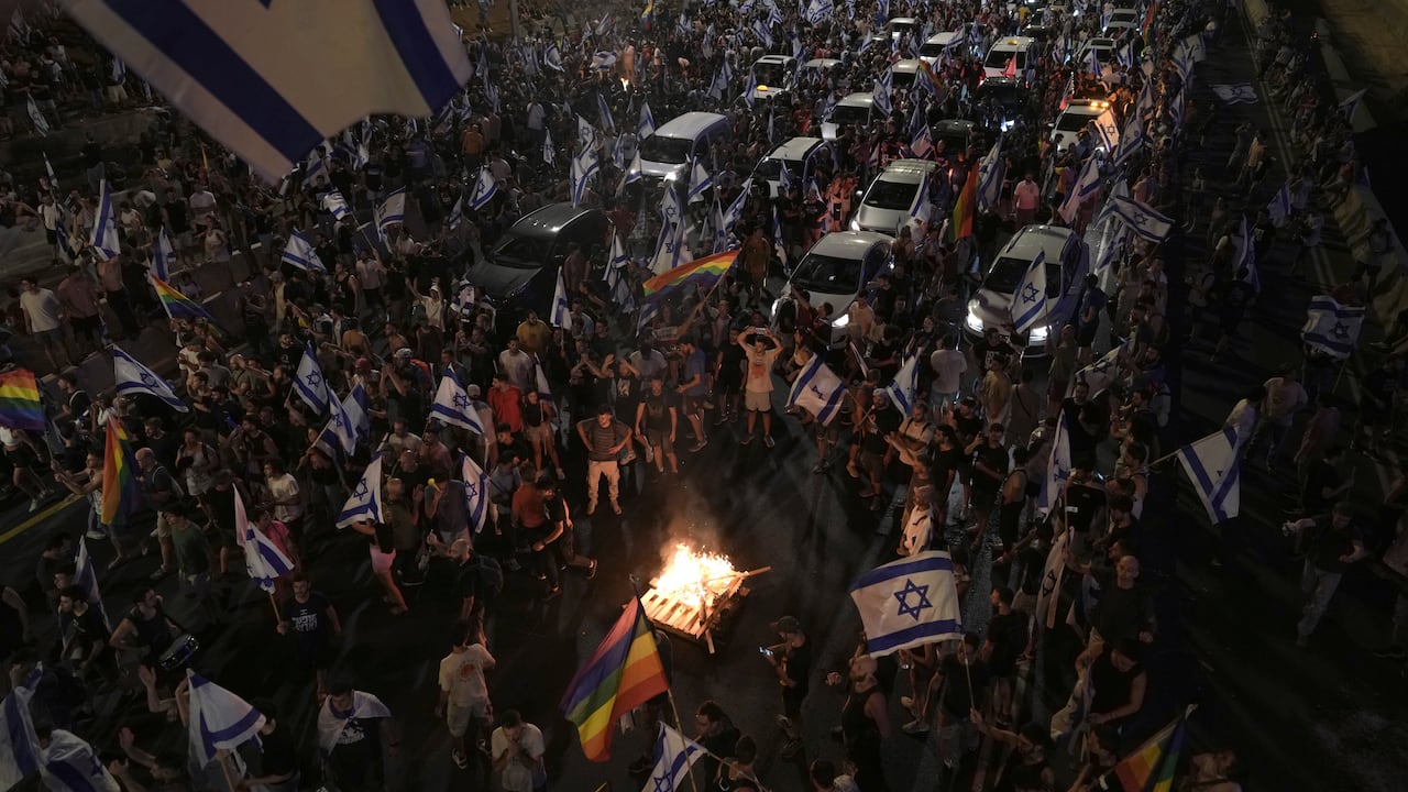 Los manifestantes encendieron un fuego mientras bloqueaban el tráfico en una carretera que cruza la ciudad durante una protesta contra los planes del gobierno de Netanyahu para reformar el sistema judicial, en Tel Aviv, el lunes 24 de julio de 2023.