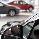 Coches nuevos en la sala de exposición del concesionario. Fondo borroso temático con efecto bokeh. Concesionario de automóviles. Vehículos de prestigio.