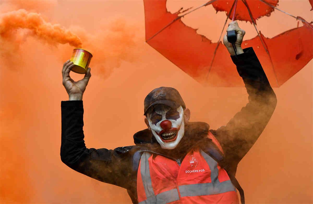 Un hombre con la máscara del Guasón, y que agita una bomba de humo, participa en una manifestación contra las reformas de las pensiones en Marsella, Francia, el 5 de diciembre de 2019. (Foto: por Clement Mhoudeau / AFP)