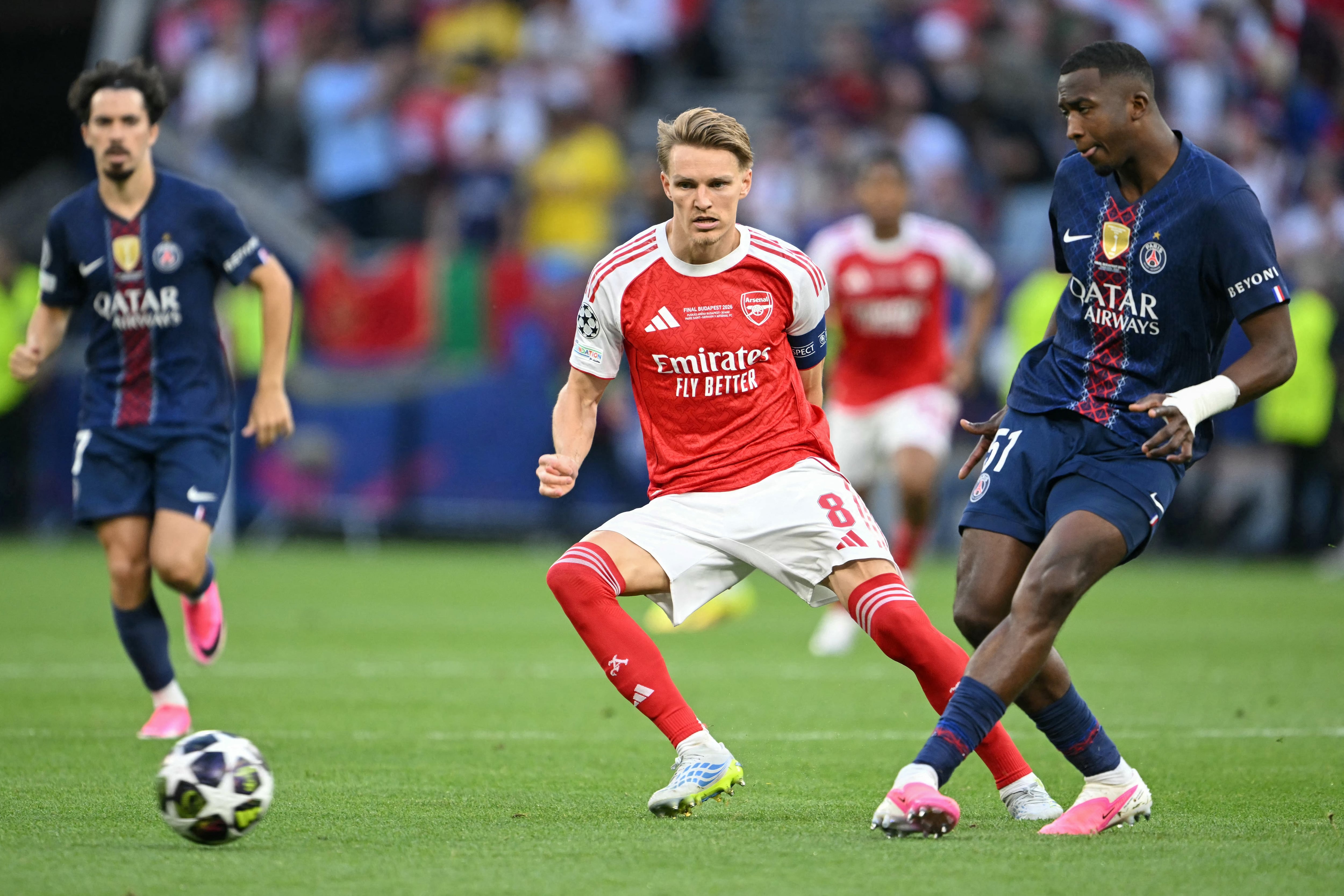 El defensa ecuatoriano del Paris Saint-Germain, Willian Pacho (derecha), número 51, pasa el balón frente al centrocampista noruego del Arsenal, Martin Odegaard (centro), número 08, durante la final de la Liga de Campeones de la UEFA entre el Paris Saint-Germain (PSG) y el Arsenal FC en el Puskás Arena de Budapest el 30 de mayo de 2026. (Foto de NICOLAS TUCAT / AFP)