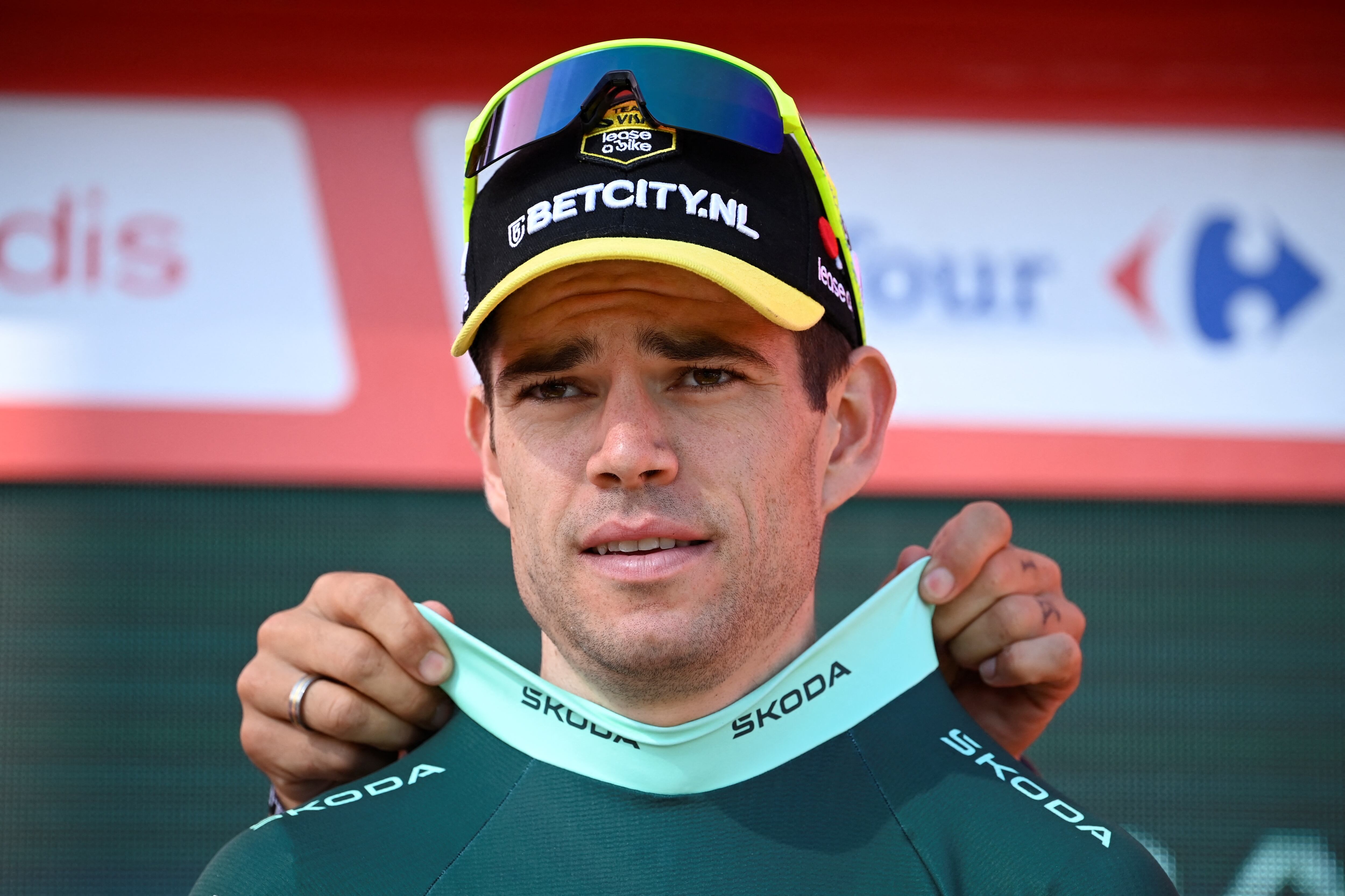The points ranking leader, Team Visma's Wout van Aert, puts on the green jersey on the podium after the stage 11 of the Vuelta a Espana, a 166.5 km race between Padron and Padron, on August 28, 2024. (Photo by MIGUEL RIOPA / AFP)