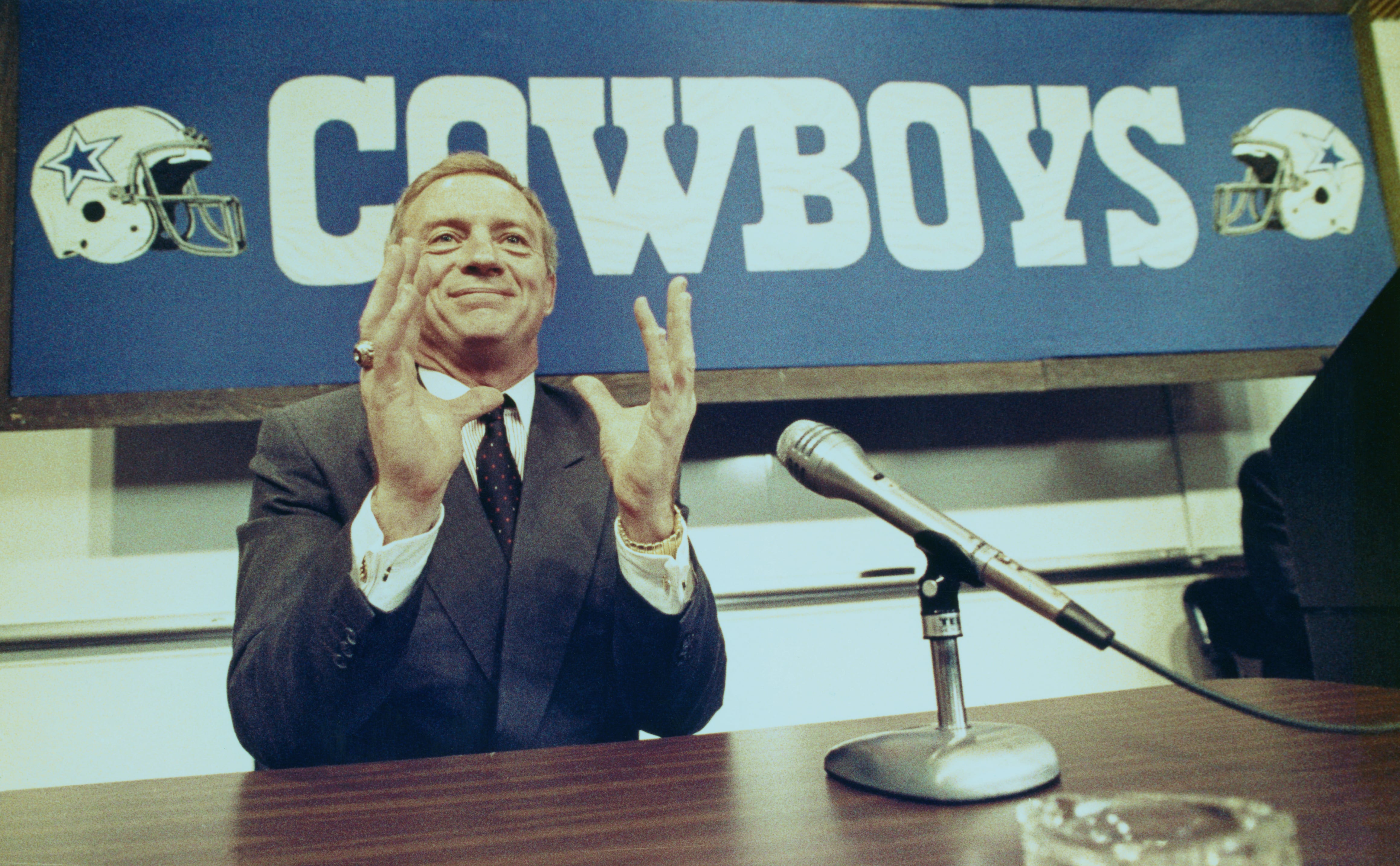 Jerry Jones, millonario petrolero de Arkansas, da una conferencia de prensa en la sede de los Dallas Cowboys el 25 de febrero por la noche durante la cual les dijo a los reunidos que su excompañero de cuarto en la universidad y compañero de equipo en Arkansas, Jimmy Johnson, reemplazaría a Tom Landry como el Entrenador en jefe de los vaqueros.