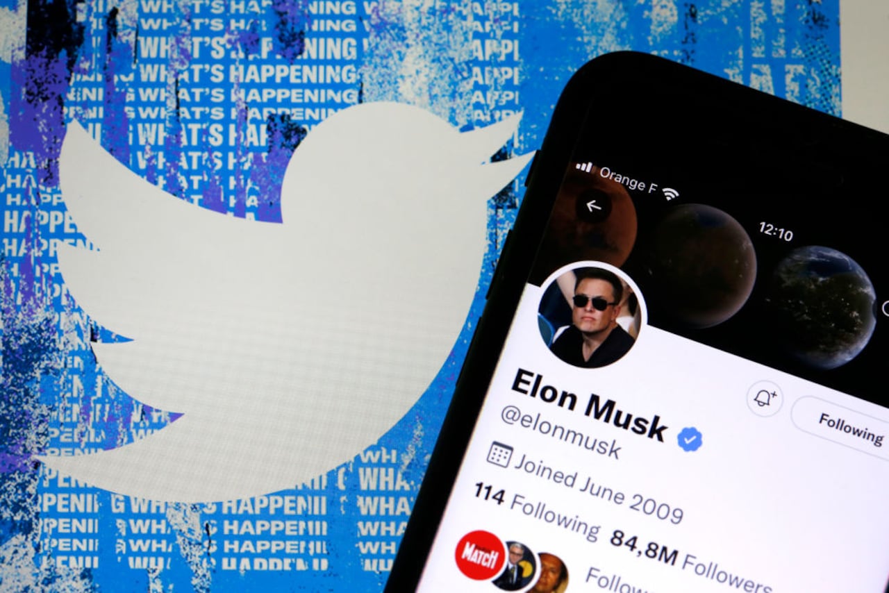 En esta ilustración fotográfica, la cuenta de Twitter de Elon Musk se muestra en la pantalla de un iPhone frente a la página de inicio del sitio web de Twitter el 26 de abril de 2022 en París, Francia. El multimillonario estadounidense Elon Musk compró la red social Twitter el lunes 25 de abril por la suma de 44.000 millones de dólares tras dos semanas de pulsos con la junta directiva de la empresa. (Ilustración fotográfica de Chesnot/Getty Images)