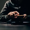 Hacker, thief is using their fingers to press passwords to break into personal data on smartphones. Concept of personal data hacking and financial hacking.