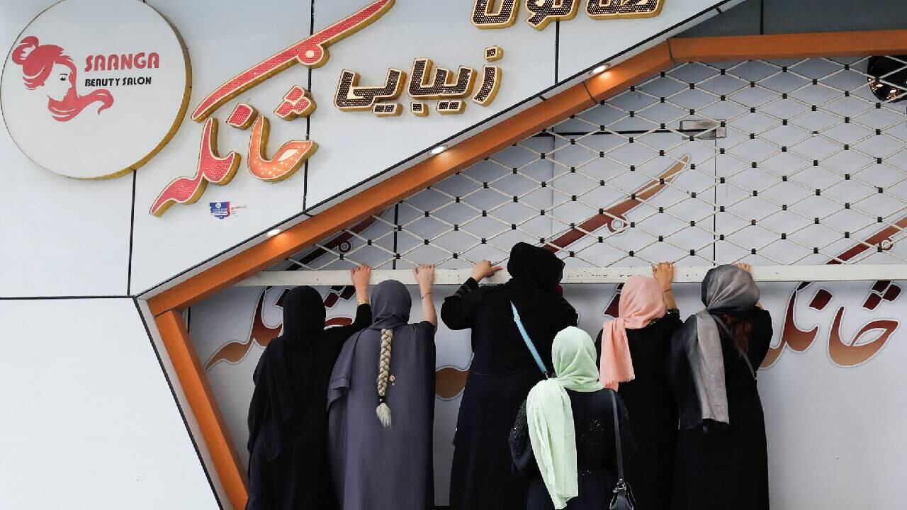 Esteticistas afganas cierran su salón de belleza en Kabul.