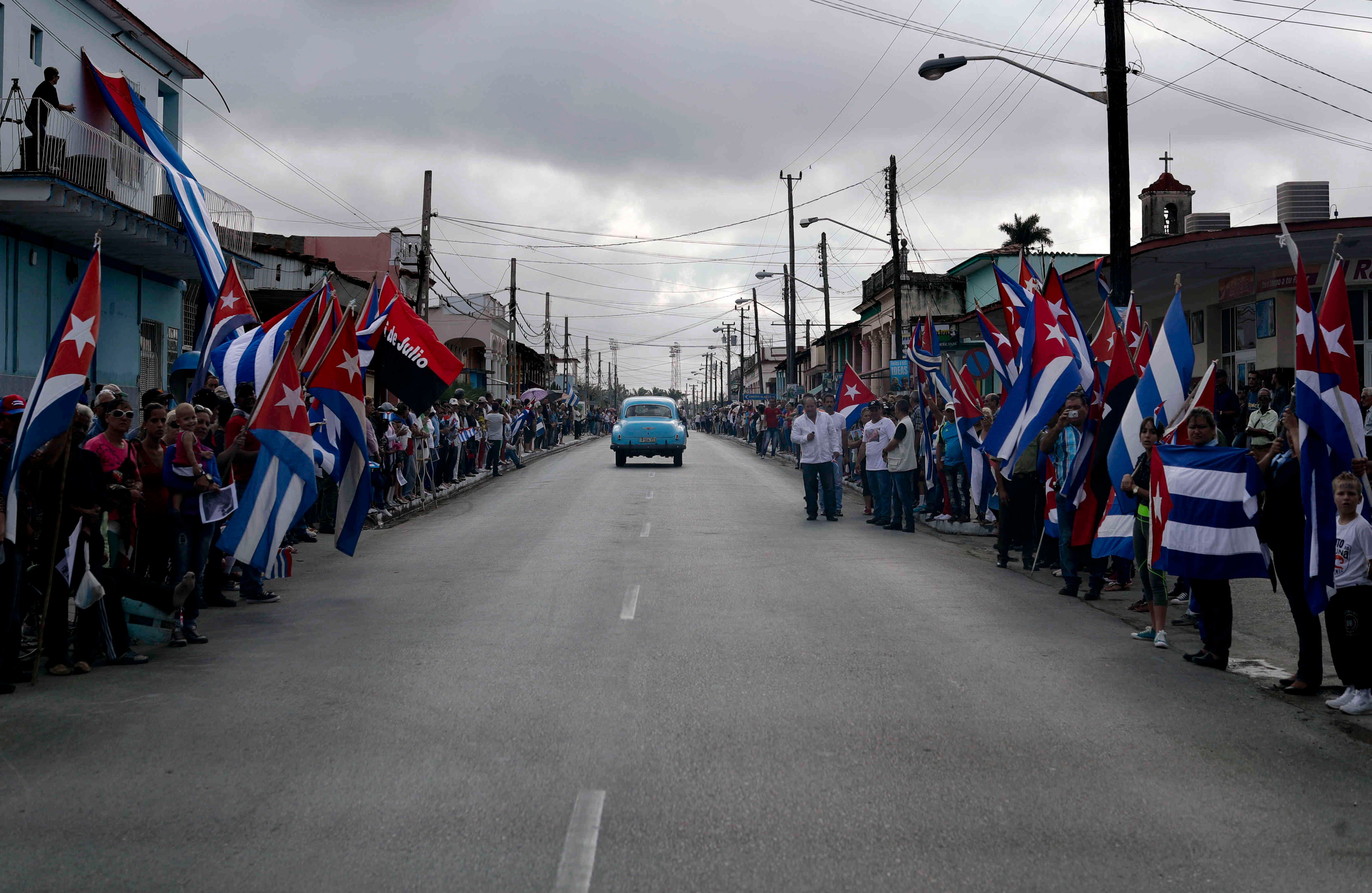 Personas sostienen banderas de Cubra durante las honras fúnebres del líder político.(AP Photo/Natacha Pisarenko).