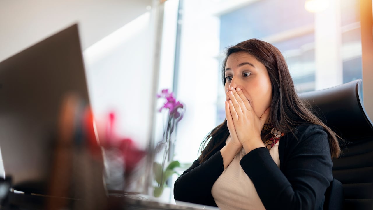Shocked young woman looking at laptop screen