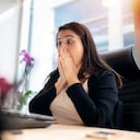 Shocked young woman looking at laptop screen