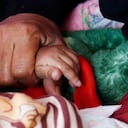 Una madre yemení toma la mano de su hijo mientras éste sufre desnutrición aguda y recibe tratamiento en un centro médico el 28 de febrero de 2023 en Sana'a, Yemen (Foto de Mohammed Hamoud/Getty Images)