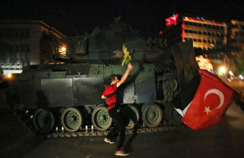 Un tanque se mueve hacia los ciudadanos mientras ellos intentan detenerlos. Foto: AP