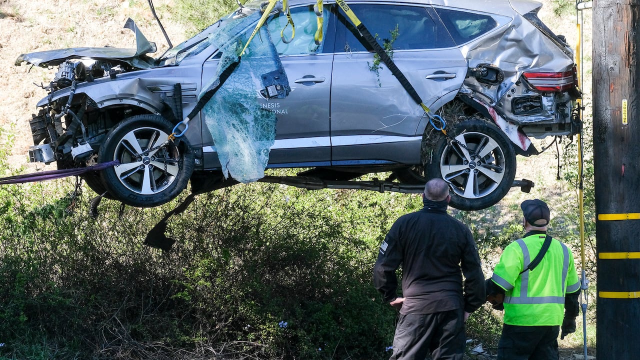 Se utiliza una grúa para levantar un vehículo luego de un accidente de vuelco que involucra al golfista Tiger Woods, el martes. 23 de 2021, en el suburbio Rancho Palos Verdes de Los Ángeles. Woods sufrió lesiones en la pierna en el accidente de un automóvil y estaba siendo operado, dijeron las autoridades y su gerente. (Foto AP / Ringo H.W. Chiu)