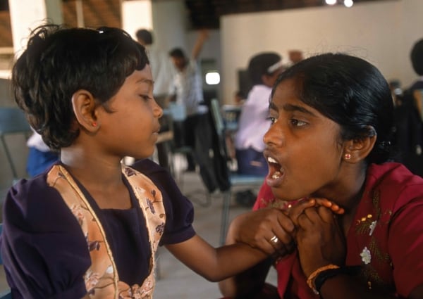 Sri Lanka: Ravindran no puede escuchar, pero sí siente las vibraciones en la garganta de su maestra. Ella está aprendiendo a hablar. La escuela para sordos emplea a 13 maestros.

