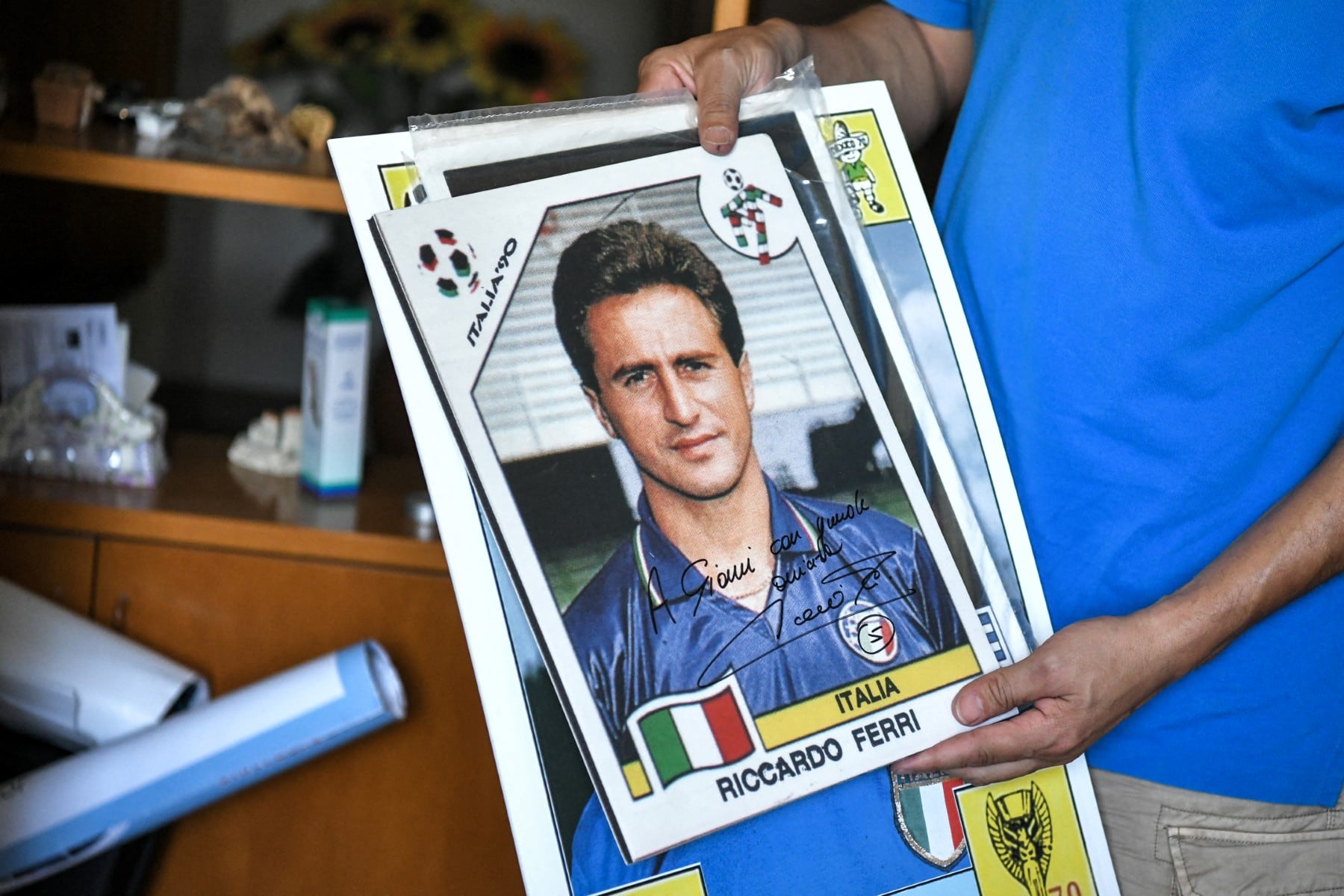 Gianni Bellini, propietario de la colección de pegatinas de fútbol más grande del mundo, sostiene una fotografía autografiada del exfutbolista italiano Riccardo Ferri, en su estudio en San Felice sul Panaro, provincia de Módena, el 18 de julio de 2018