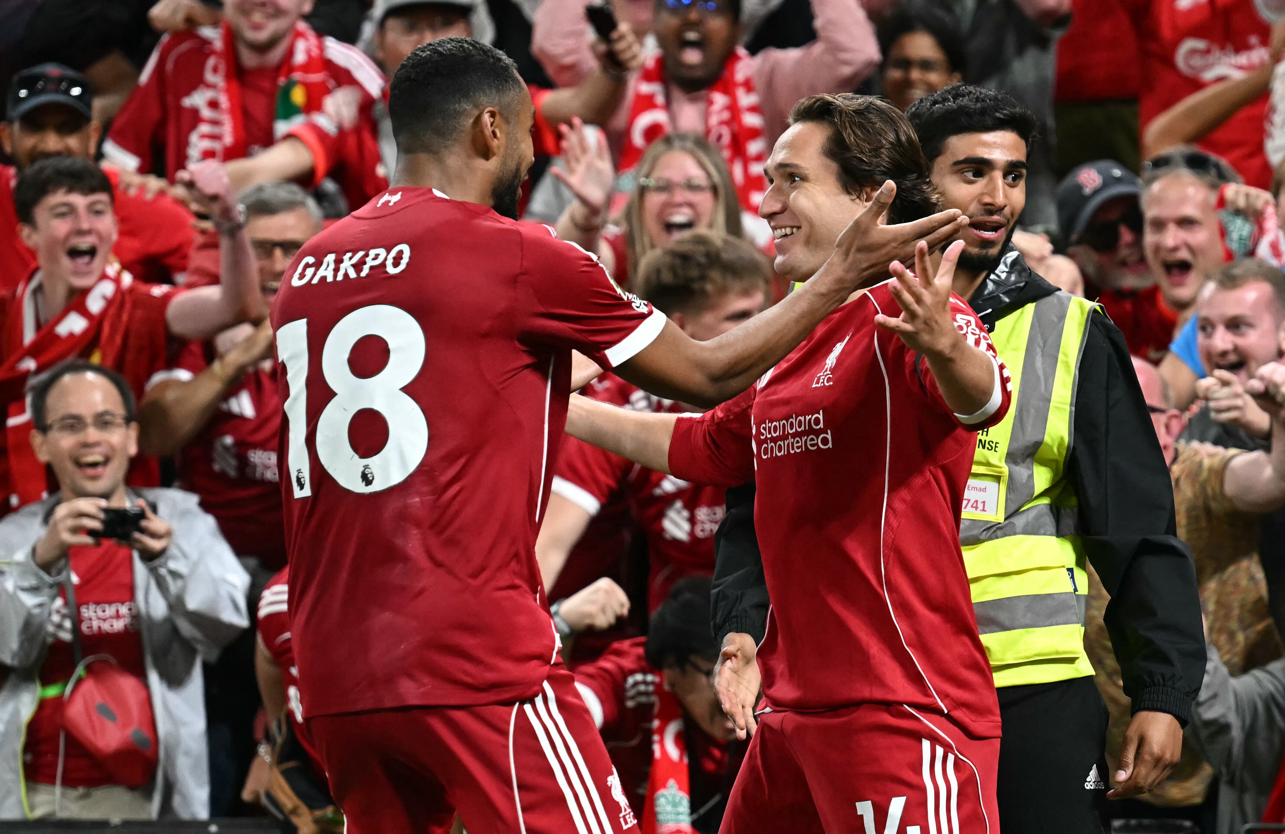 El delantero italiano #14 del Liverpool, Federico Chiesa (D), celebra con el delantero holandés #18 del Liverpool, Cody Gakpo (I), después de marcar su tercer gol durante el partido de fútbol de la Premier League inglesa entre Liverpool y Bournemouth en Anfield en Liverpool, noroeste de Inglaterra, el 15 de agosto de 2025. (Foto de Paul ELLIS / AFP).