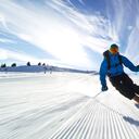 Esquiador profesional esquiando en pistas de los Alpes suizos hacia la cámara.