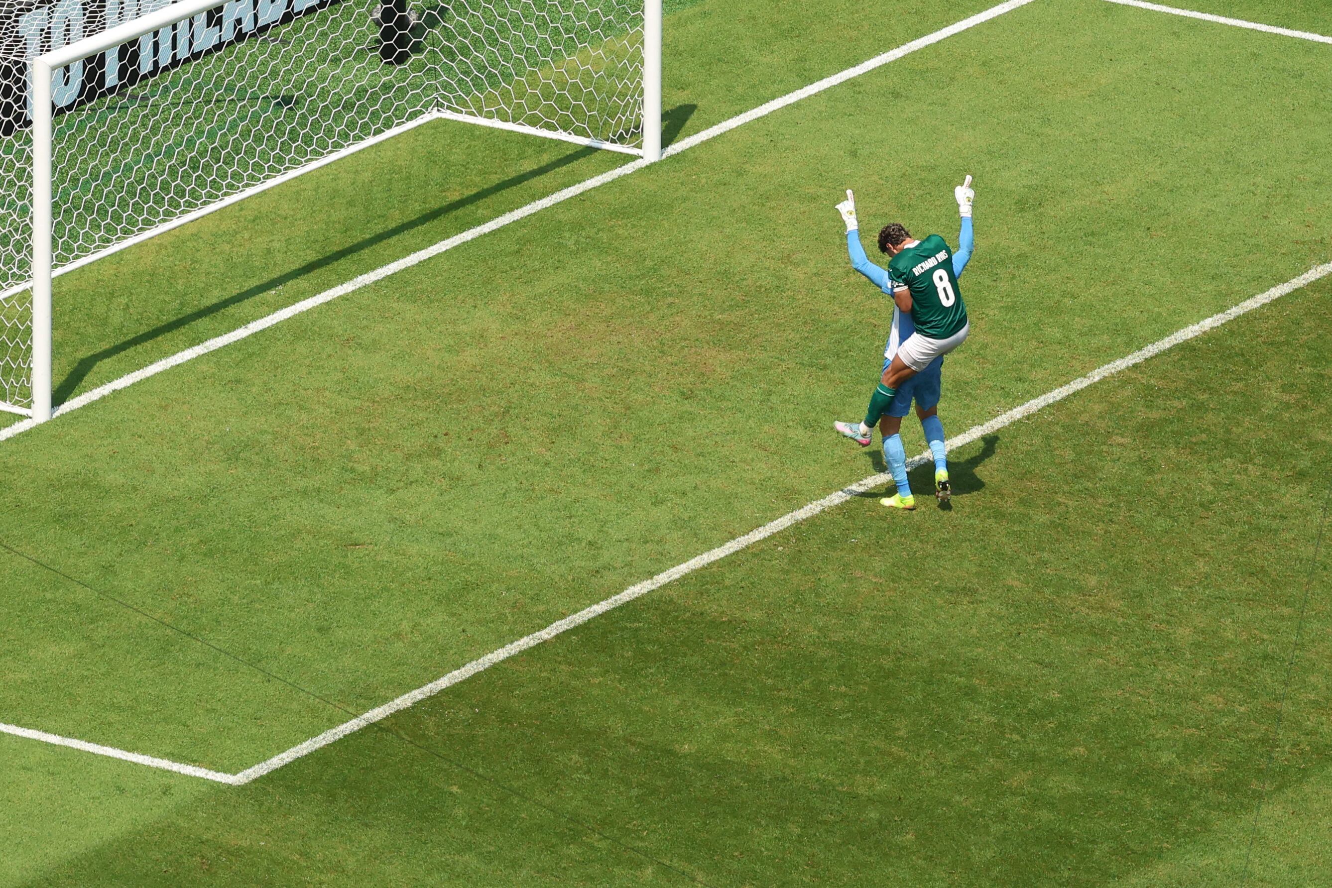 El portero brasileño #21 del Palmeiras, Weverton, celebra con su compañero de equipo, el mediocampista colombiano #08 Richard Ríos, después de ganar el partido de fútbol brasileño de octavos de final de la Copa Mundial de Clubes de la FIFA 2025 entre Palmeiras y Botafogo.