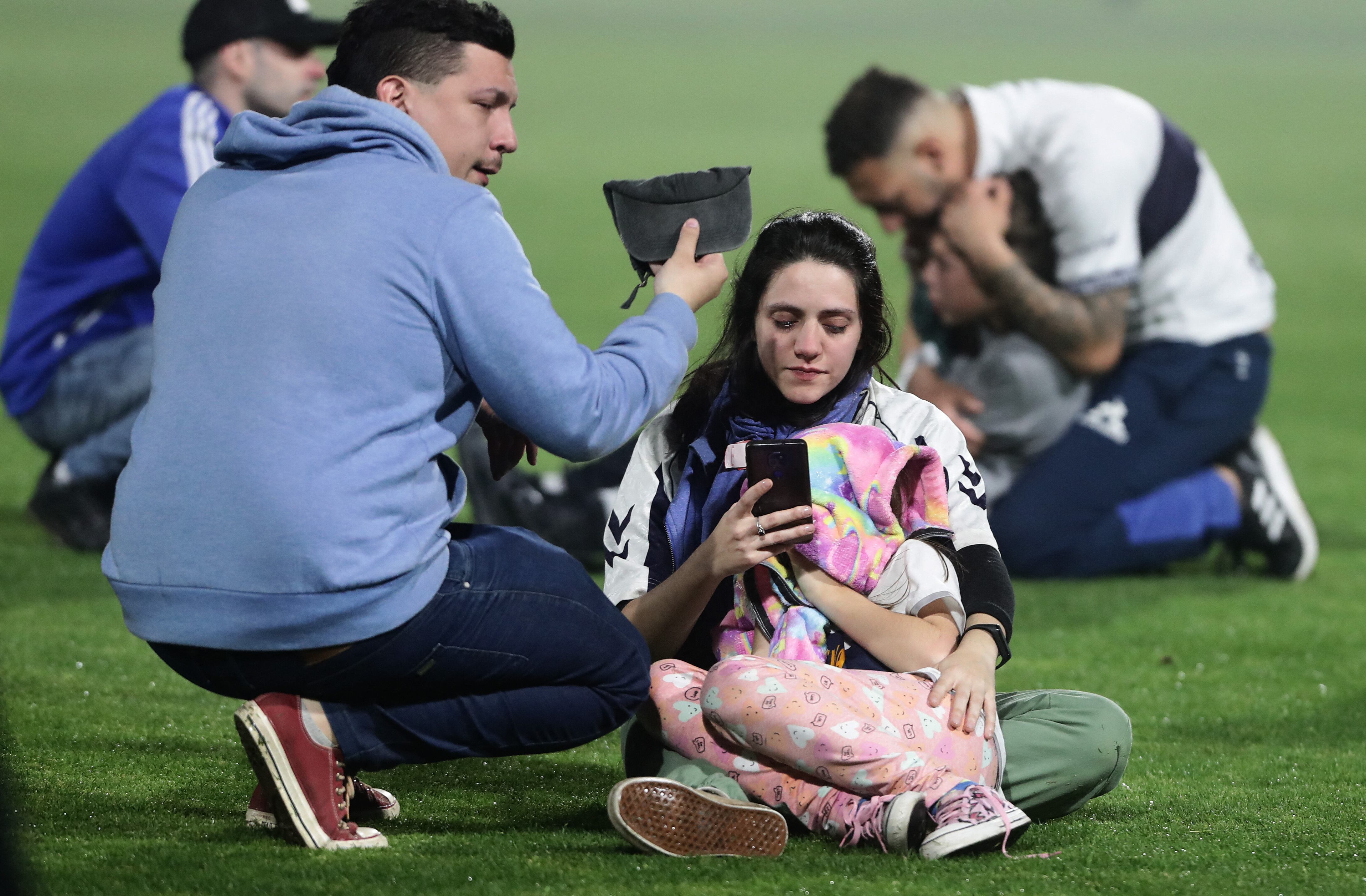 Fans of Gimnasia y Esgrima react after the police threw tear gas outside the Juan Carmelo Zerillo stadium and entered the field during the Argentine Professional Football League Tournament 2022 match between Gimnasia y Egrima and Boca Juniors in La Plata, Argentina, on October 6, 2022. - A supporter of the Gimnasia soccer club died during serious incidents that broke out during an Argentine league match between his team and Boca Juniors on Thursday in Buenos Aires, according to local authorities. "I confirm that there is a dead person. This person died of cardiac arrest," said the Minister of Security of the province of Buenos Aires, Sergio Berni. The match was stopped in the 9th minute due to clashes inside and outside the stadium. (Photo by ALEJANDRO PAGNI / AFP)