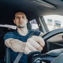 El joven conductor emocionado que sostiene un volante con las manos mira hacia adelante con curiosidad mientras conduce un automóvil a alta velocidad en la autopista. Un hombre con cinturón de seguridad en el interior de un vehículo.