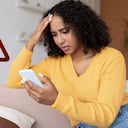 Persona angustiada tras descubrir que está siendo espiada por su celular.