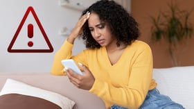 Persona angustiada tras descubrir que está siendo espiada por su celular.