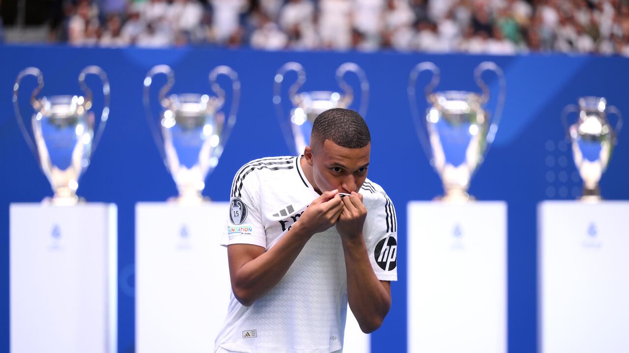 MADRID, SPAIN - JULY 16: Real Madrid new signing, Kylian Mbappe kisses the Real Madrid badge as he is unveiled at Estadio Santiago Bernabeu on July 16, 2024 in Madrid, Spain. (Photo by David Ramos/Getty Images)
