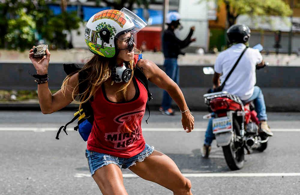 Ataviada con un short, una camiseta y un casco, Caterina Ciarcelluti, modelo y entrenadora de fitness de 44 años, lanzaba piedras contra militares el 1 de mayo. Su musculosa figura le valió el sobrenombre de "Mujer Maravilla", convertida en una especie de superheroína para adversarios de Maduro.
