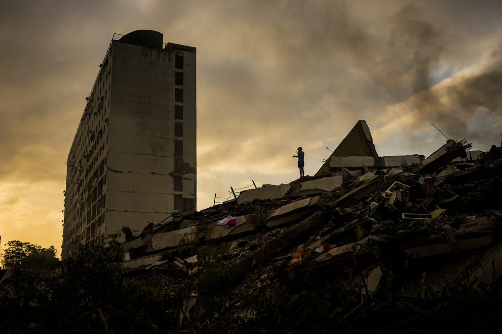 Un hombre se encuentra en la cima de una montaña de escombros tres días después de que dos terremotos sacudieran La Guaira, Venezuela, el sábado 27 de junio de 2026.