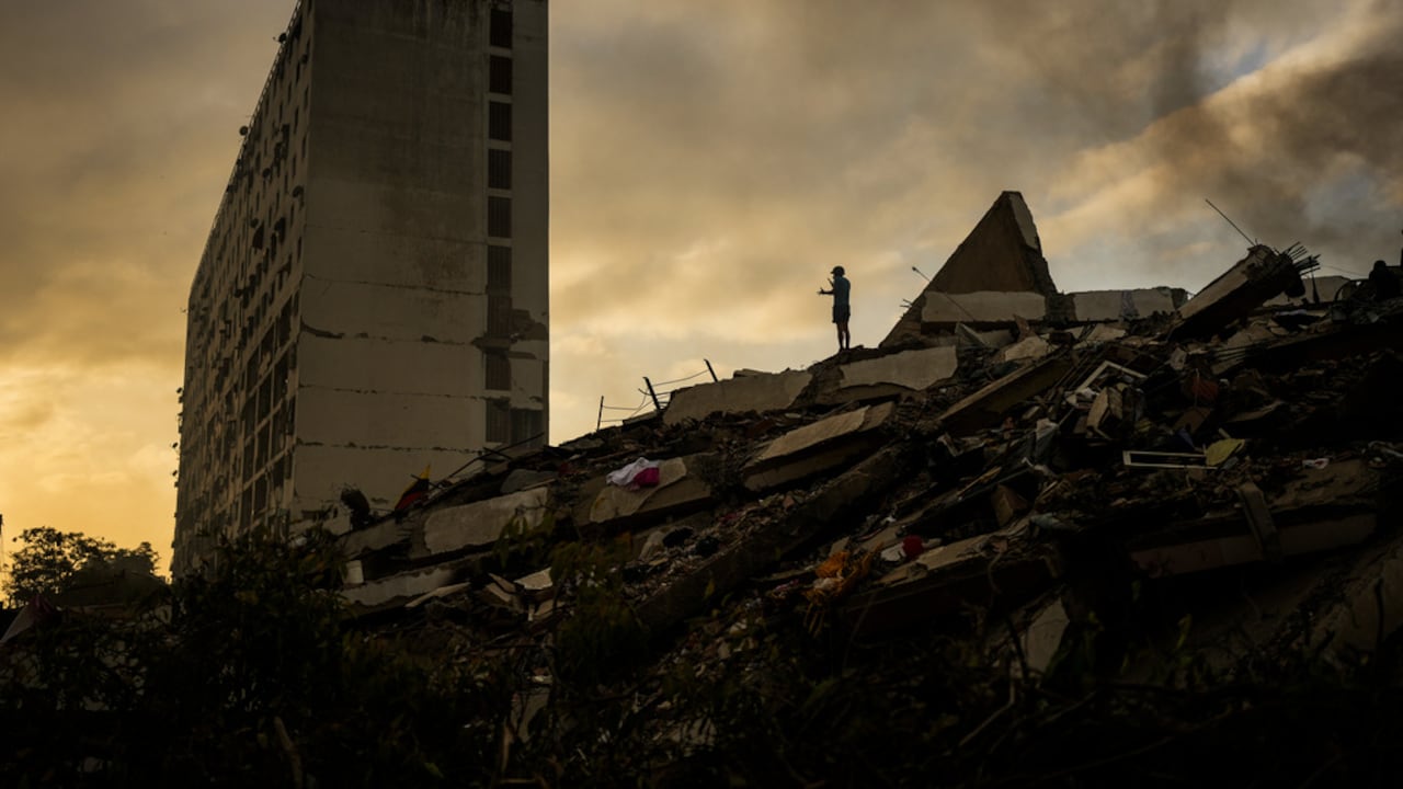 Un hombre se encuentra en la cima de una montaña de escombros tres días después de que dos terremotos sacudieran La Guaira, Venezuela, el sábado 27 de junio de 2026.