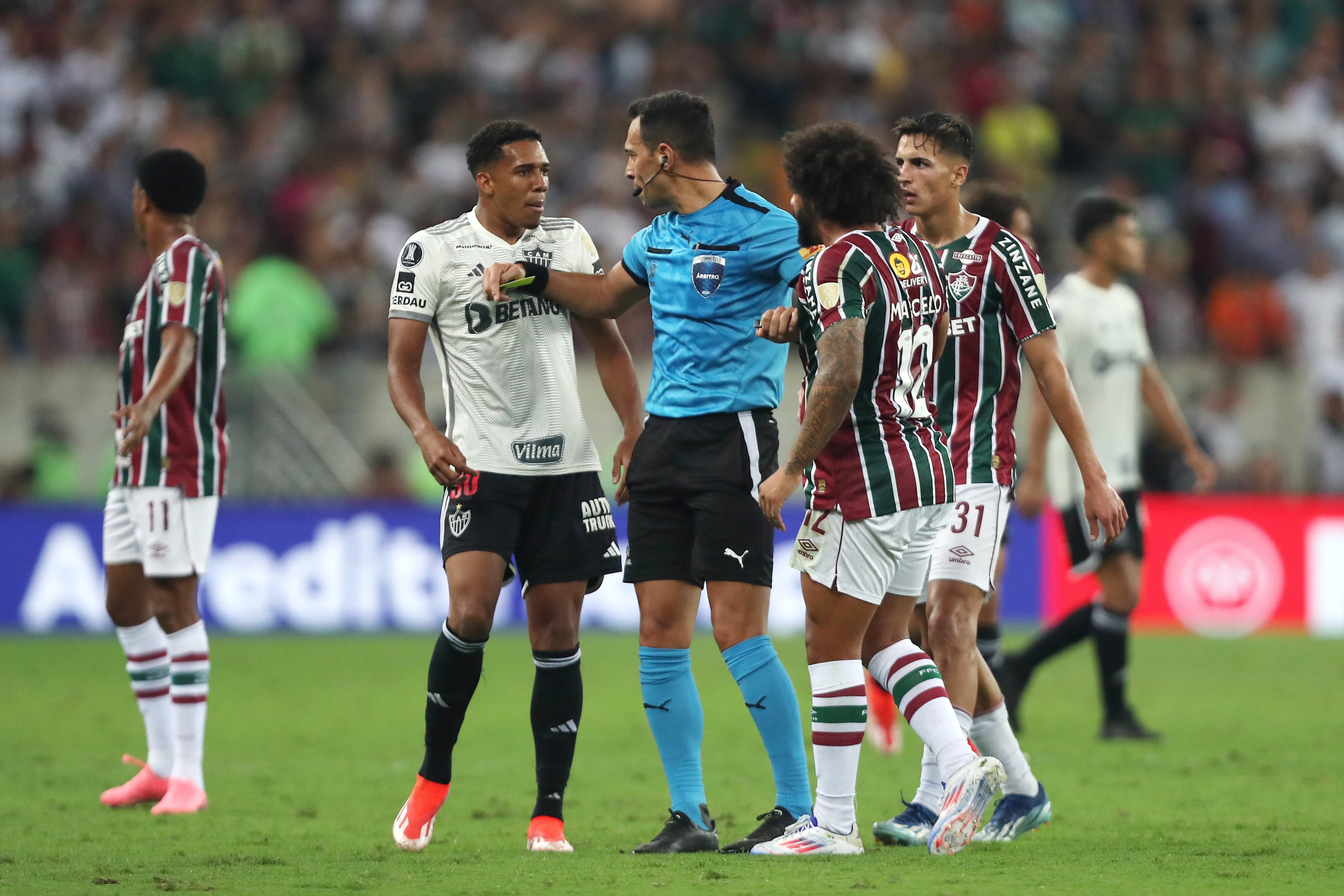 RIO DE JANEIRO, BRAZIL - SEPTEMBER 18: Referee Facundo Tello separates Marcelo of Fluminense as he argues with Brahian Palacios of Atletico Mineiro during the Copa CONMEBOL Libertadores 2024 Quarterfinal match between Fluminense and Atletico Mineiro at Maracana Stadium on September 18, 2024 in Rio de Janeiro, Brazil. (Photo by Wagner Meier/Getty Images)