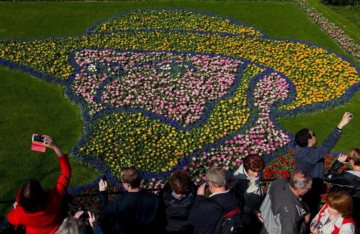 Los turistas toman fotos al arreglo floral de siete millones de flores que retrata al pintor neerlandés Vincent van Gogh en Lisse, Países Bajos. (AP)