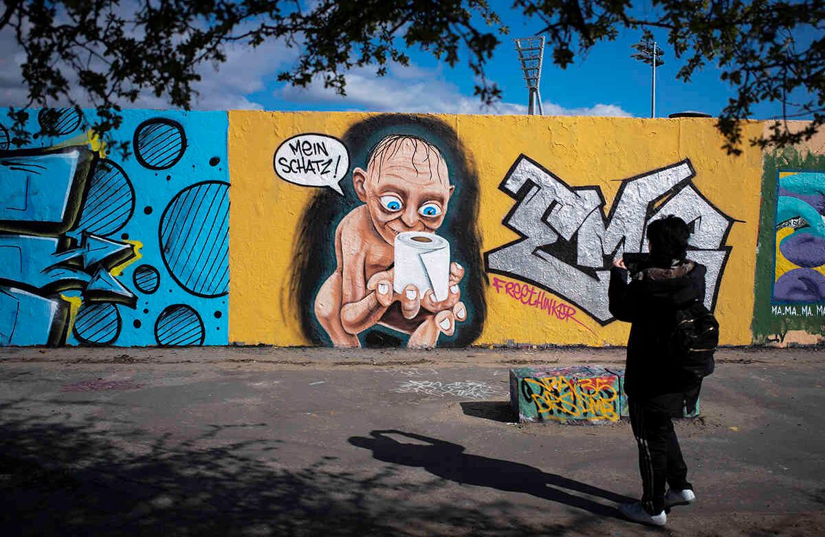  En este grafiti se ilustra a Gollum, personaje del Señor de los Anillos, sosteniendo un rollo de papel higiénico. El sitio es el parque público Mauerpark, en Berlín, Alemania.  Para frenar la propagación del coronavirus, el gobierno alemán ha restringido considerablemente la vida pública y ha pedido a los ciudadanos que se queden en casa. Foto: Markus Schreiber/ AP