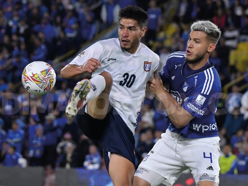 Juan Pablo Vargas disputando una pelota contra Michael Nike Gómez, delantero del Boyacá Chicó