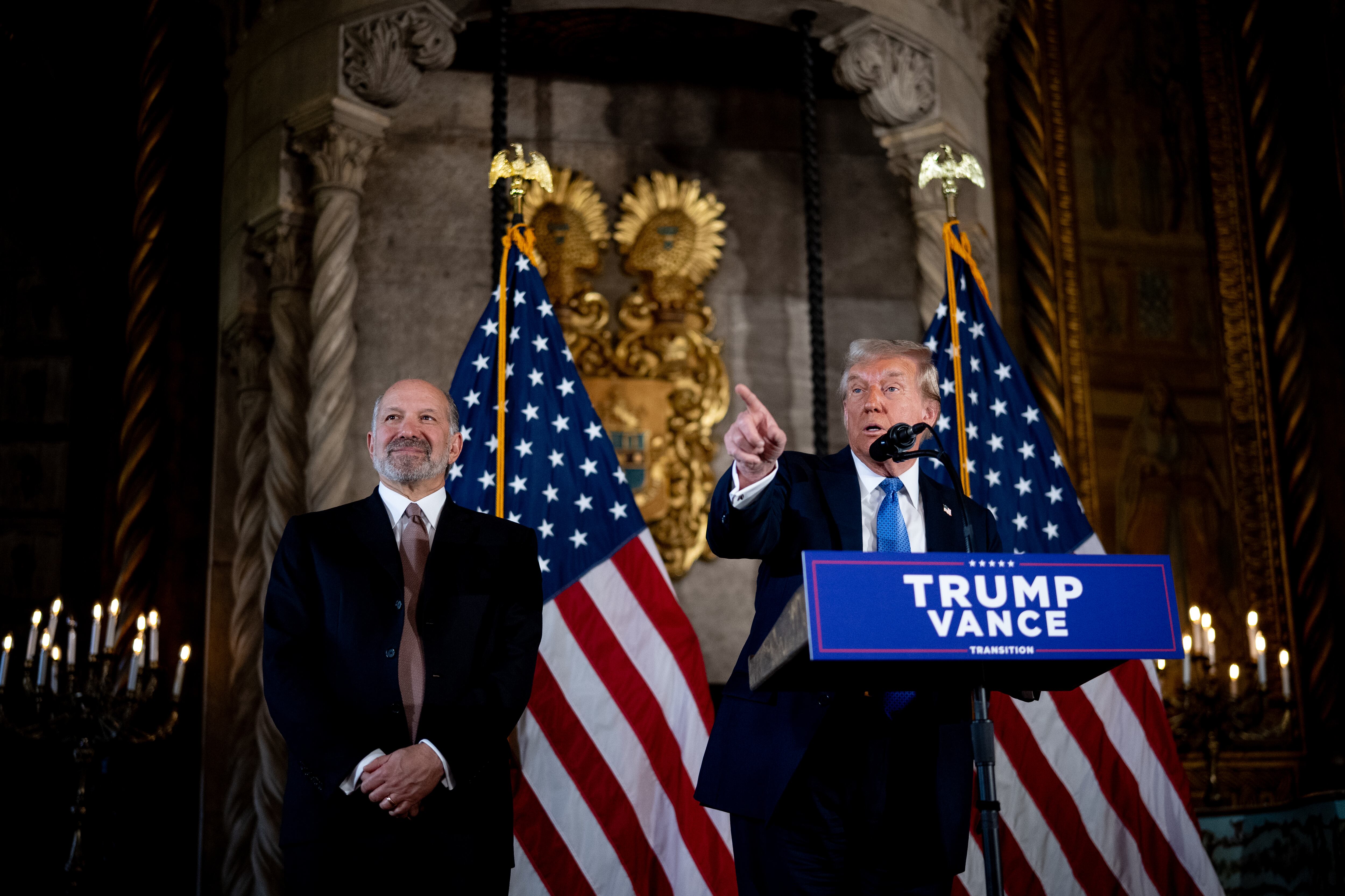 El presidente electo de Estados Unidos, Donald Trump, acompañado por el elegido por Trump para Secretario de Comercio, Cantor Fitzgerald, presidente y director ejecutivo, Howard Lutnick, responde una pregunta de un periodista durante una conferencia de prensa en el resort Mar-a-Lago de Trump. el 16 de diciembre de 2024 en Palm Beach, Florida. En una conferencia de prensa que duró más de una hora, Trump anunció que SoftBank invertirá más de 100.000 millones de dólares en proyectos en Estados Unidos, incluidos 100.000 empleos relacionados con la inteligencia artificial, y luego respondió preguntas sobre Siria, Israel, Ucrania, la economía, las elecciones de gabinete y muchos otros temas. otros temas. (Foto de Andrew Harnik/Getty Images)