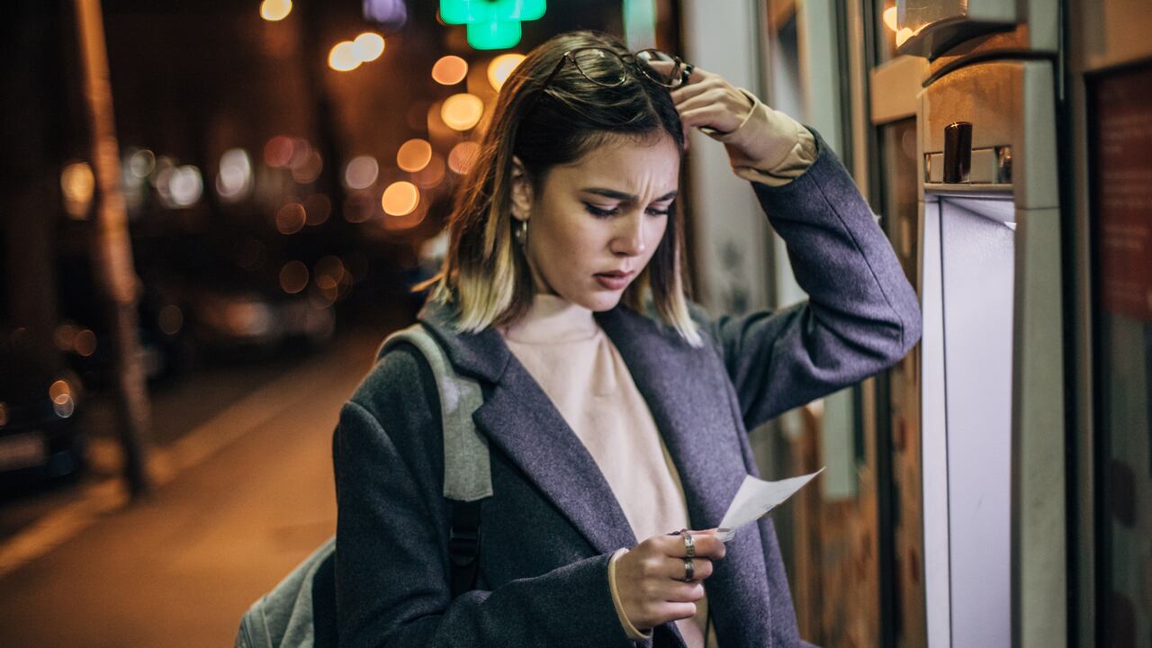 Worried woman with the hand on her forehead had problems with ATM machine