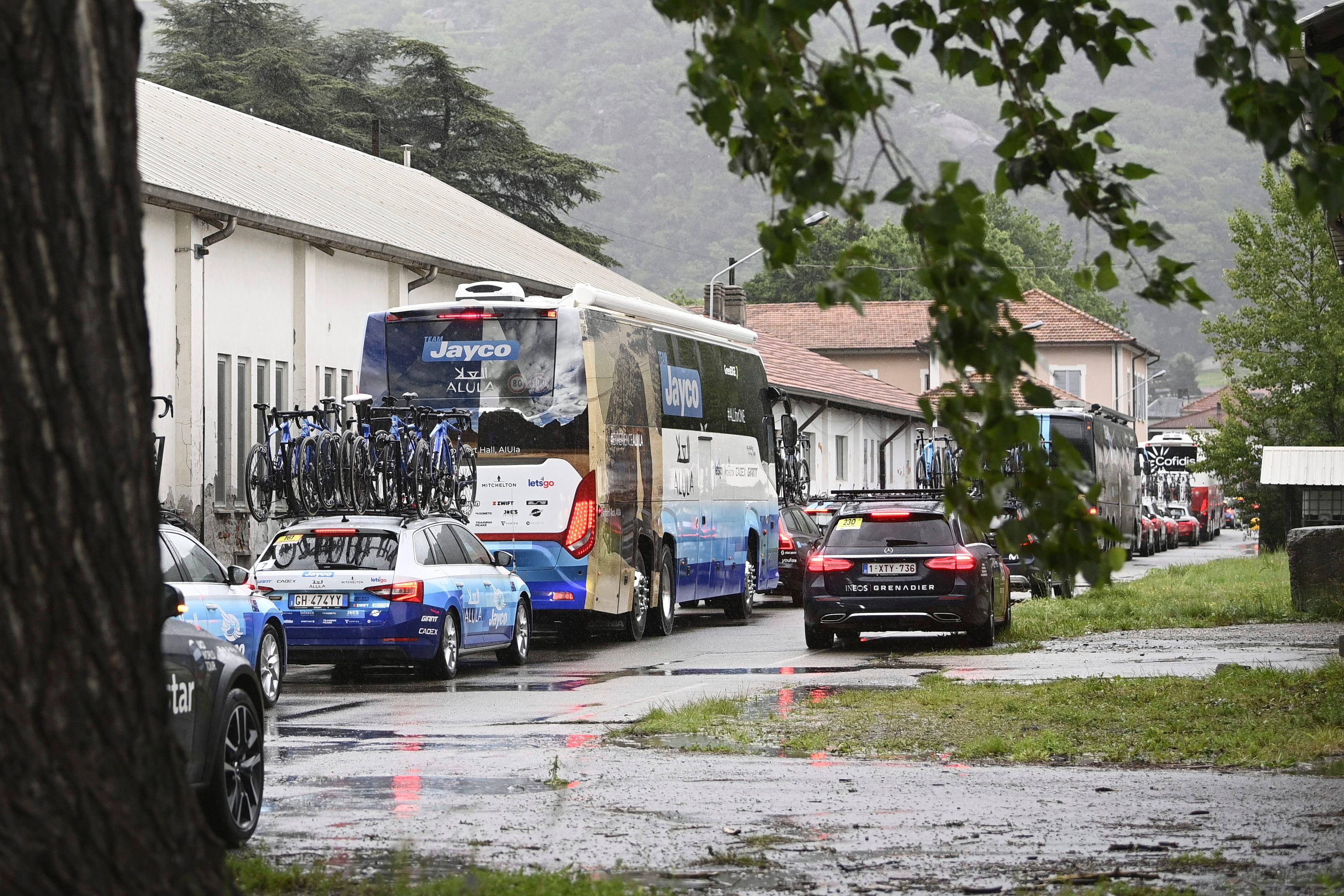 A queue of vehicles, some with cyclists' bicycles on top, is seen leaving after the first section of stage 13 of the Giro d'Italia cycling race, from Borgofranco d'Ivrea to Crans Montana, Switzerland, was canceled due to bad weather conditions, in Borgofranco d'Ivrea, Italy, Friday, May 19, 2023. (Fabio Ferrari/LaPresse via AP)